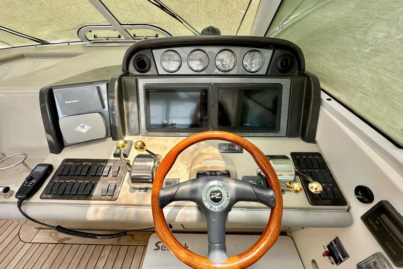 Tsuki Yacht Photos Pics Helm of 2005 Sea Ray 48 Sundancer with wood steering wheel and dual displays.