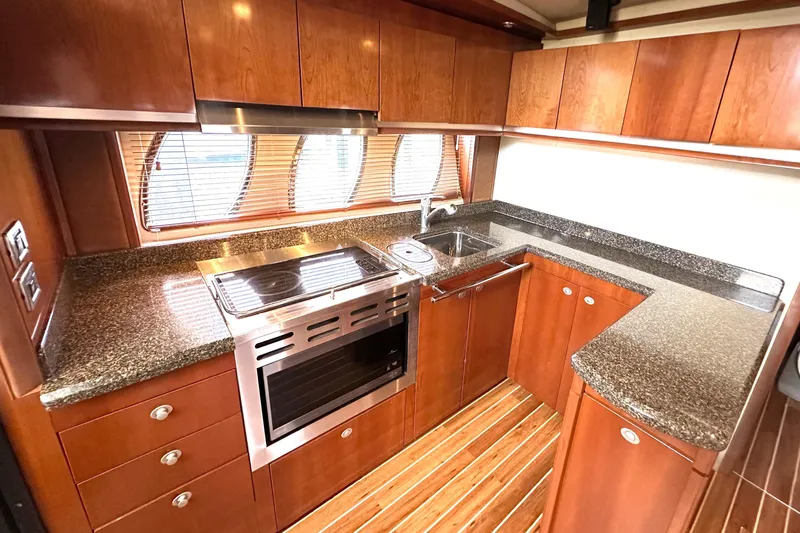 Tsuki Yacht Photos Pics Luxurious 2005 Sea Ray 48 Sundancer yacht kitchen with wood cabinetry and granite countertops.