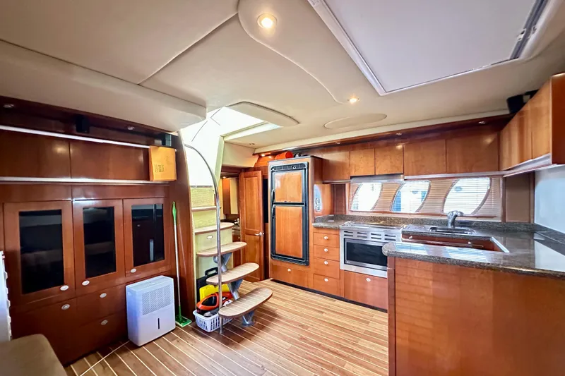 Tsuki Yacht Photos Pics Luxurious interior of 2005 Sea Ray 48 Sundancer yacht with modern kitchen and wooden cabinetry.
