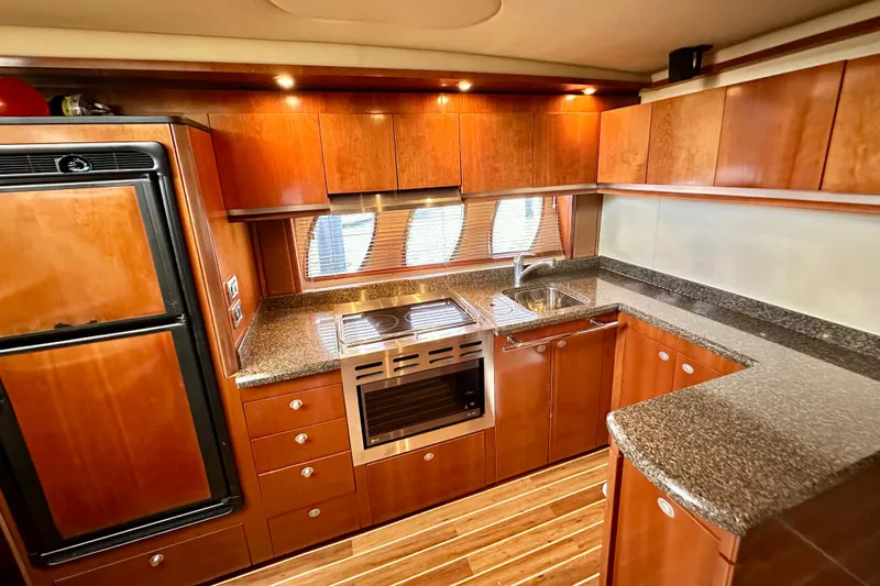 Tsuki Yacht Photos Pics Luxurious kitchen interior of 2005 Sea Ray 48 Sundancer yacht with wood cabinetry and modern appliances.