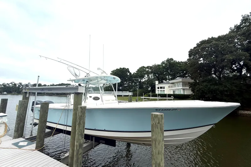  Yacht Photos Pics 2009 Regulator 34SS boat docked by waterfront home, surrounded by trees.