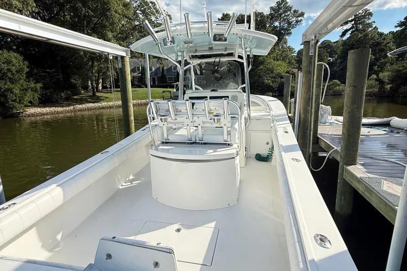  Yacht Photos Pics 2009 Regulator 34SS boat docked, featuring spacious deck and seating, surrounded by lush greenery.