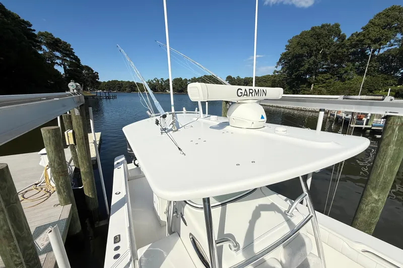  Yacht Photos Pics 2009 Regulator 34SS boat docked, featuring Garmin equipment, surrounded by serene water and trees.