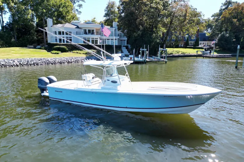  Yacht Photos Pics 2009 Regulator 34SS boat on calm water near a luxurious waterfront home.
