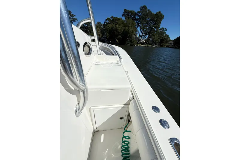  Yacht Photos Pics 2009 Regulator 34SS boat deck with railing, on calm water, surrounded by trees.