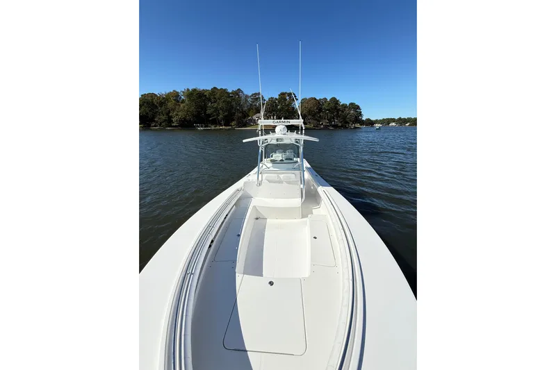  Yacht Photos Pics 2009 Regulator 34SS boat on calm water, clear sky, and forested shoreline.