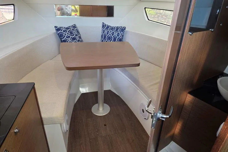  Yacht Photos Pics 2020 Jeanneau Leader 9.0 WA cabin interior with seating and table, featuring modern design.