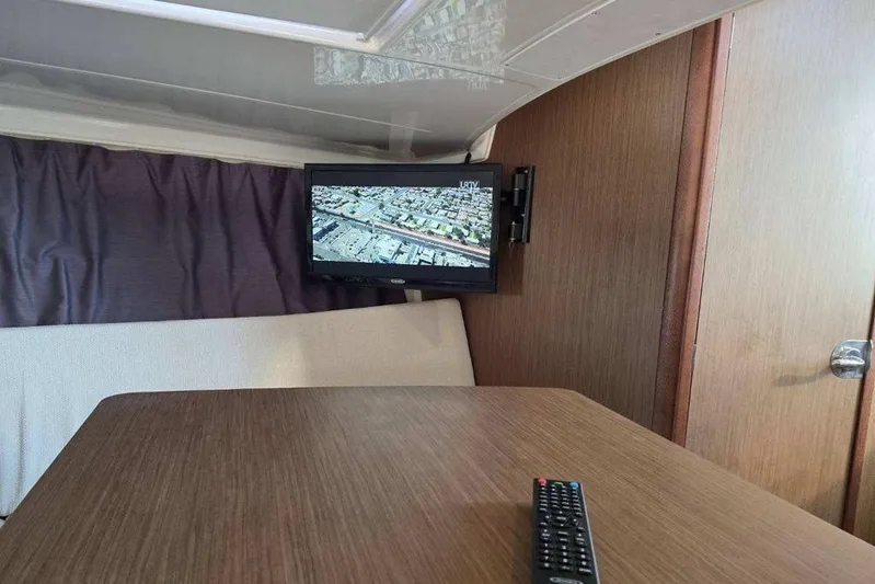  Yacht Photos Pics Interior of 2020 Jeanneau Leader 9.0 WA with TV and remote on table.