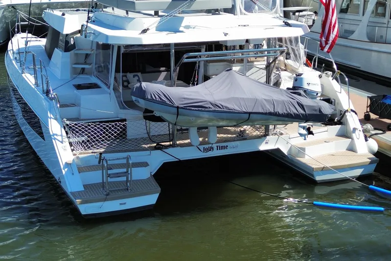 Jolly Time Yacht Photos Pics Leopard 42 catamaran, 2021 model, docked with covered dinghy and American flag.