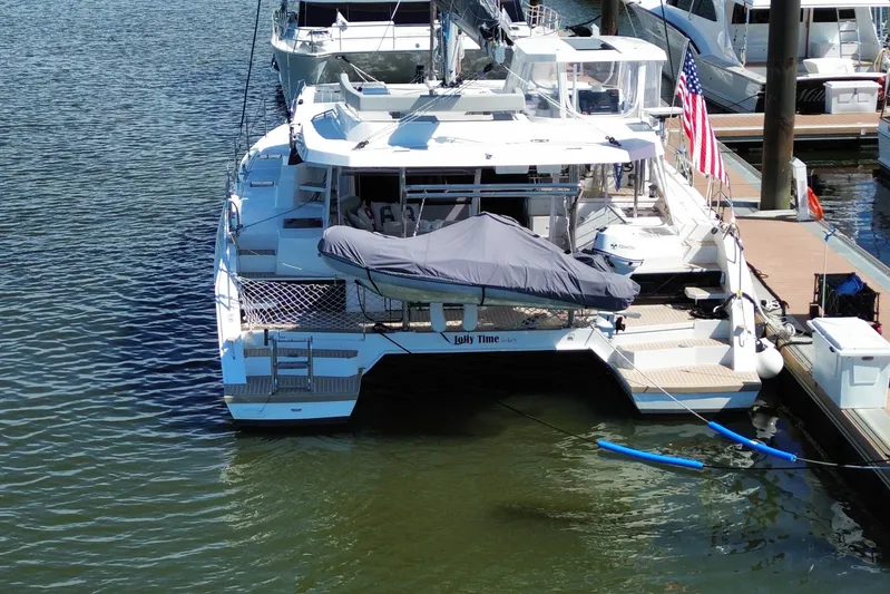Jolly Time Yacht Photos Pics Leopard 42 catamaran docked, 2021 model, with covered dinghy and American flag.