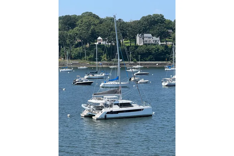 Jolly Time Yacht Photos Pics Sailboats anchored in a scenic harbor, featuring a 2021 Leopard 42 catamaran.