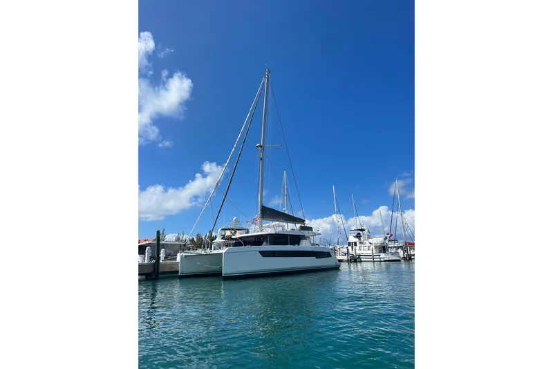 Jolly Time Yacht Photos Pics 2021 Leopard 42 catamaran docked in a sunny marina, clear blue sky.