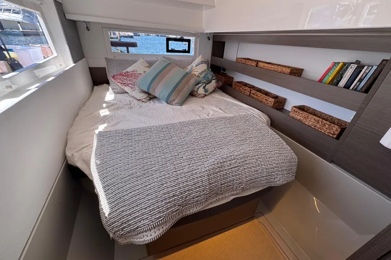 Jolly Time Yacht Photos Pics Cozy bedroom in 2021 Leopard 42 yacht with bed, pillows, and shelves.