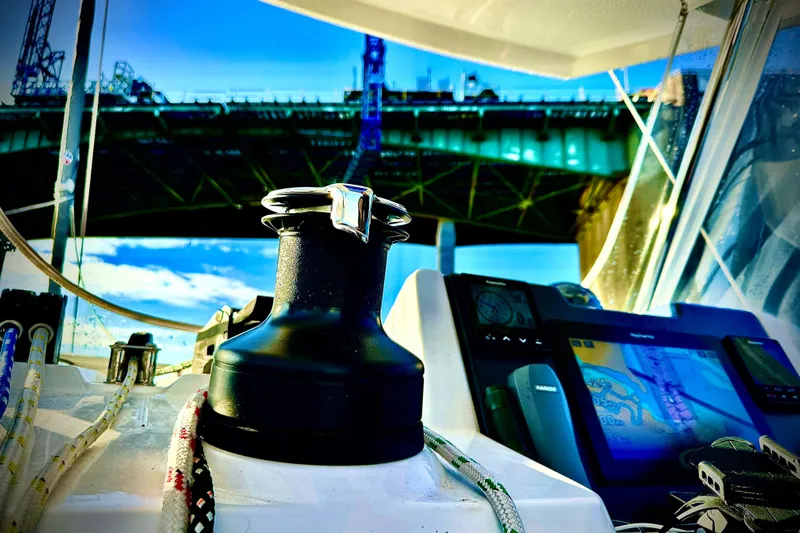 Jolly Time Yacht Photos Pics Sailing on a 2021 Leopard 42 catamaran under a bridge, featuring navigation equipment.