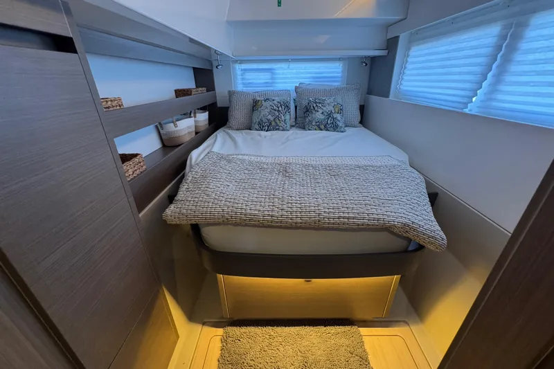 Jolly Time Yacht Photos Pics Cozy bedroom interior of 2021 Leopard 42 yacht with modern decor and ambient lighting.