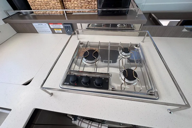 Jolly Time Yacht Photos Pics Modern kitchen stove on Leopard 42 yacht, 2021 model, with three burners and control knobs.