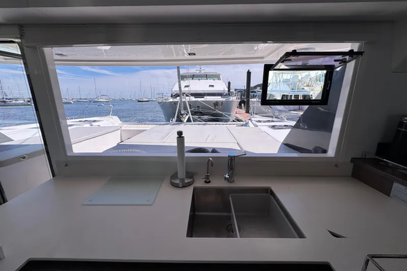 Jolly Time Yacht Photos Pics Interior view from a 2021 Leopard 42 yacht kitchen, overlooking marina and boats.