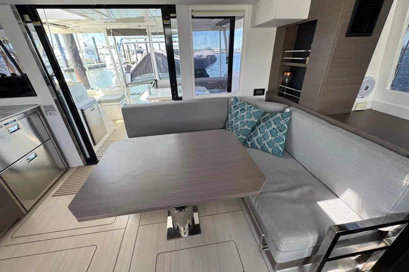 Jolly Time Yacht Photos Pics Modern Leopard 42 yacht interior with dining area, stylish cushions, and marina view, 2021 model.