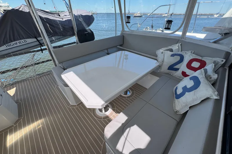 Jolly Time Yacht Photos Pics Leopard 42 yacht interior with cushioned seating, table, and nautical-themed pillows, 2021 model.