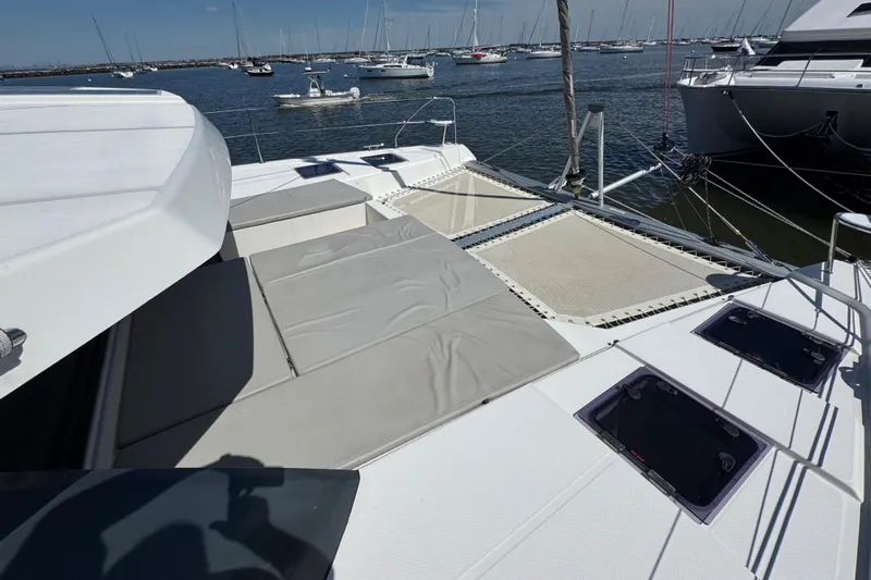 Jolly Time Yacht Photos Pics Leopard 42 catamaran deck with sunbathing area, anchored in a marina, 2021 model.