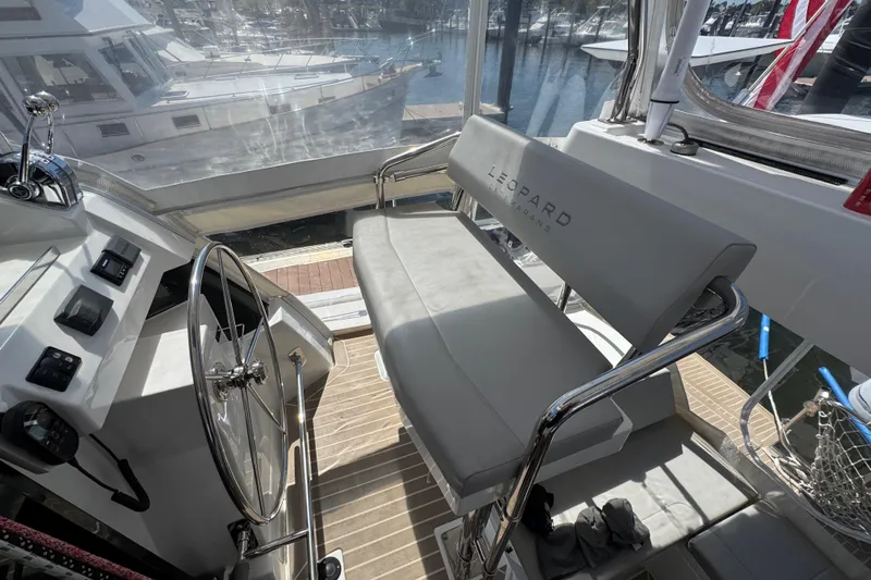 Jolly Time Yacht Photos Pics Helm station of 2021 Leopard 42 catamaran with steering wheel and cushioned seating.