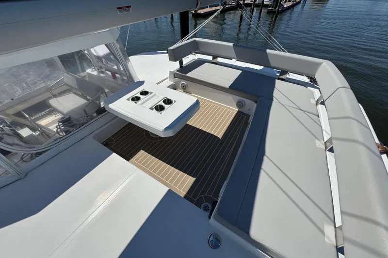 Jolly Time Yacht Photos Pics Leopard 42 catamaran deck with seating and table, 2021 model, docked by the water.