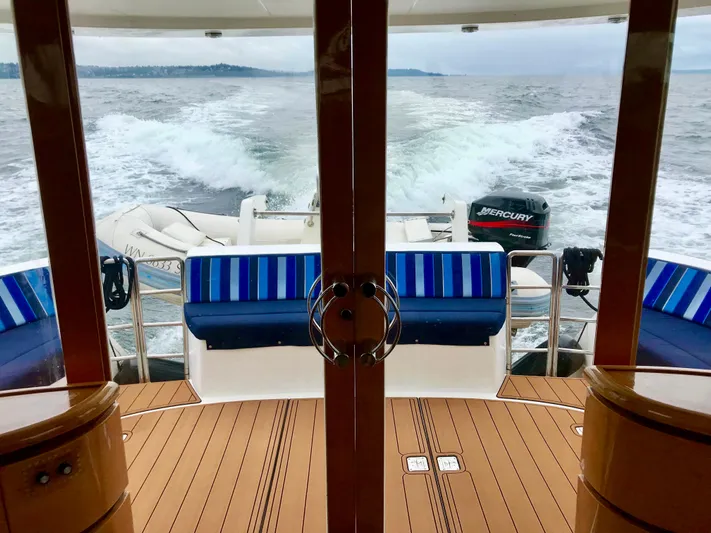  Yacht Photos Pics Luxury yacht Prima 5230 cruising on open water, featuring striped seating and Mercury engine.