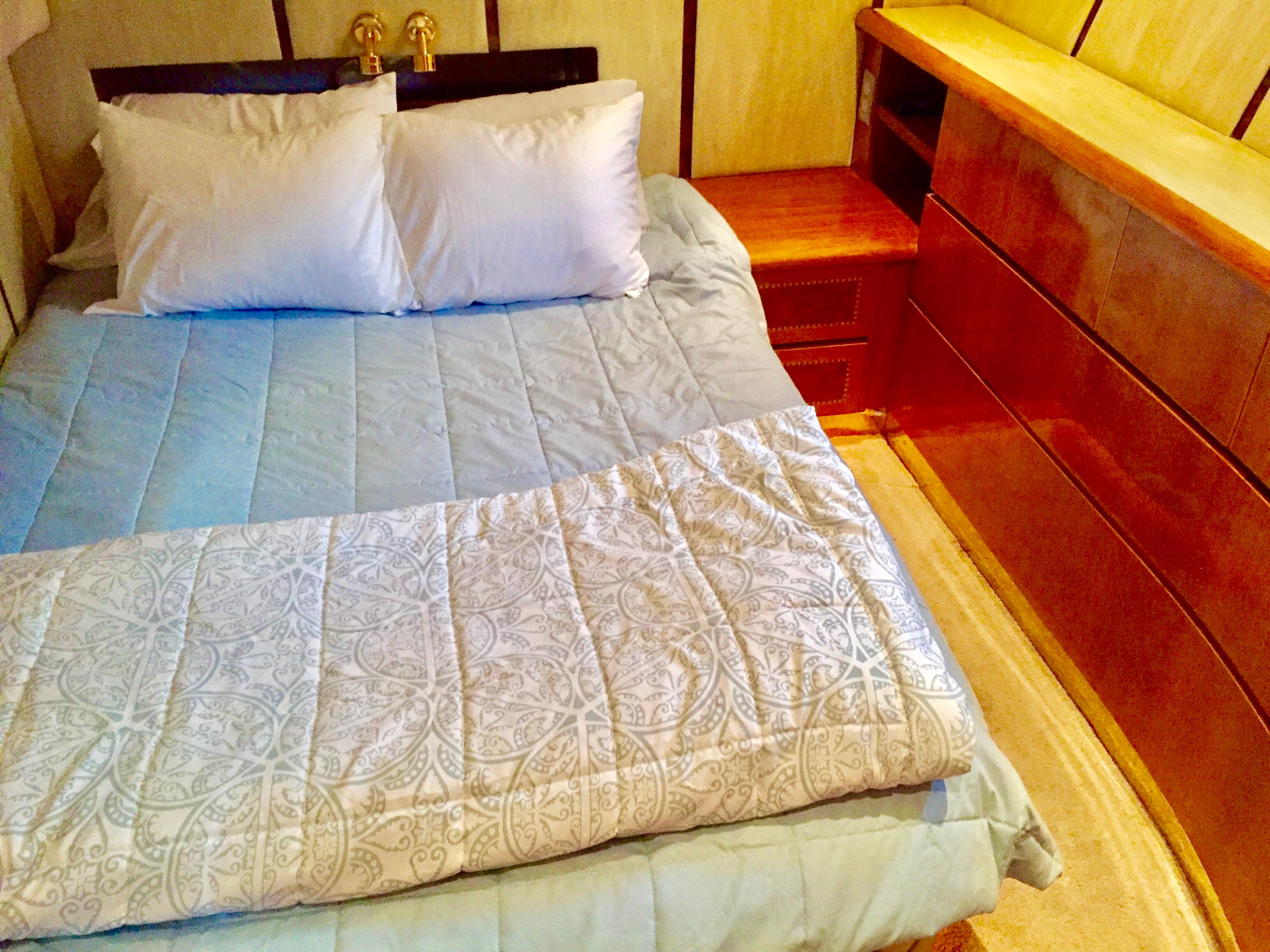 Cozy bedroom with a neatly made bed, wooden furniture, and elegant bedding. Prima 5230, 1999.