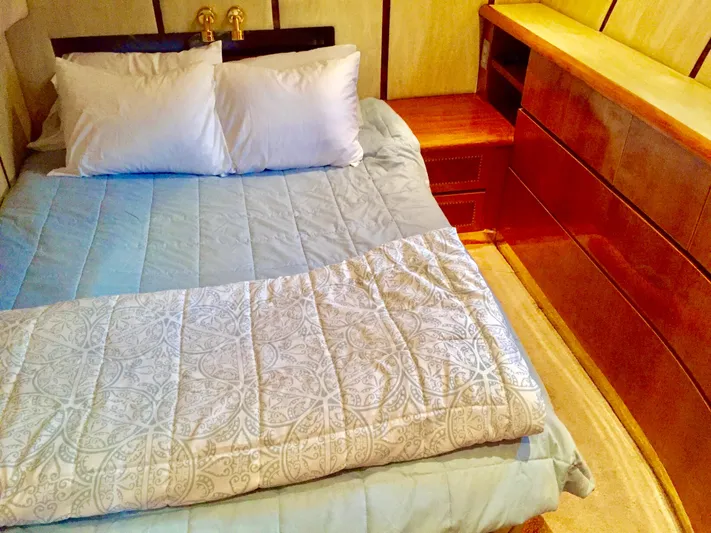  Yacht Photos Pics Cozy bedroom with a neatly made bed, wooden furniture, and elegant bedding. Prima 5230, 1999.
