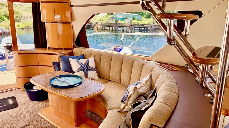  Yacht Photos Pics Luxurious Prima 5230 yacht interior with plush seating and elegant wooden accents, dockside view.