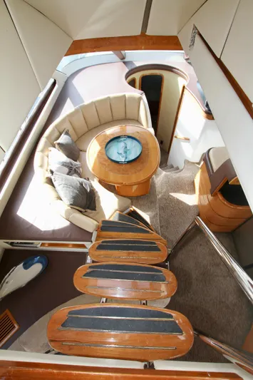  Yacht Photos Pics Interior of a 1999 Prima 5230 yacht with wooden stairs and cozy seating area.