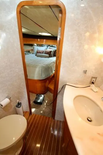  Yacht Photos Pics Luxurious yacht bathroom with wood accents, sink, and view into cozy bedroom. Prima 5230, 1999.