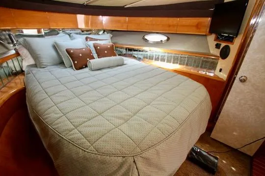  Yacht Photos Pics Luxurious cabin interior of 1999 Prima 5230 yacht with cozy bed and elegant decor.