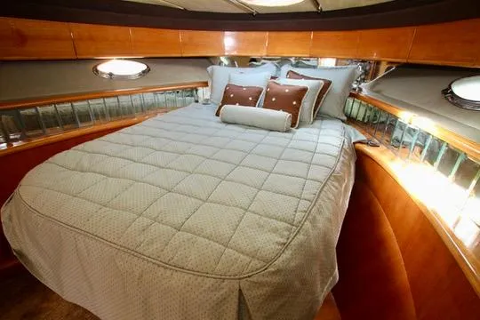  Yacht Photos Pics Luxurious Prima 5230 yacht bedroom interior with elegant bedding, wood accents, and porthole windows.
