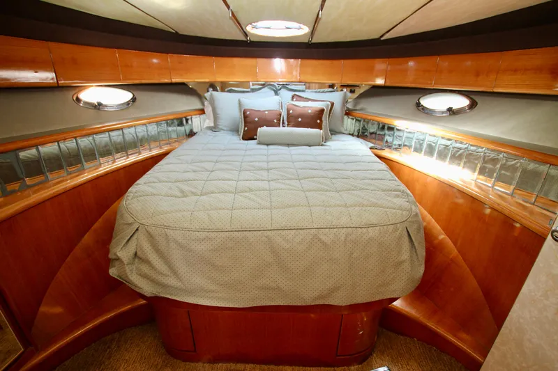  Yacht Photos Pics Luxurious cabin interior of a 1999 Prima 5230 yacht with elegant bedding and wood finish.