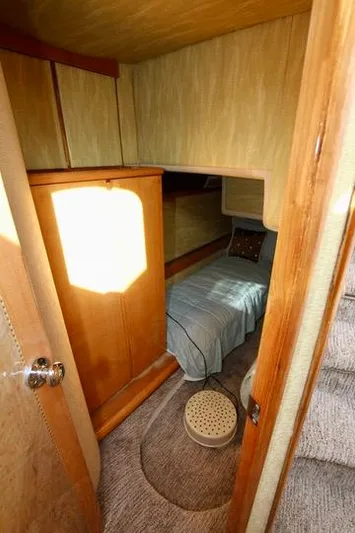  Yacht Photos Pics Cozy cabin interior of 1999 Prima 5230 boat with bed and wooden furnishings.