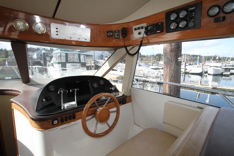  Yacht Photos Pics Interior view of a 1999 Prima 5230 boat cockpit with steering wheel and control panel.