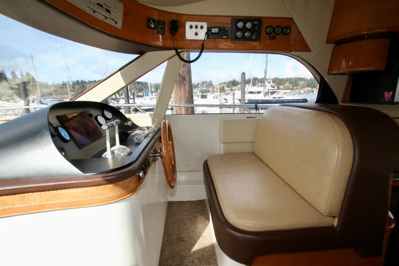  Yacht Photos Pics Interior of a 1999 Prima 5230 boat with steering wheel and seating area.