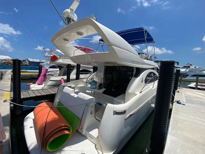  Yacht Photos Pics Azimut 46 yacht from 2000 docked at a marina under a clear blue sky.