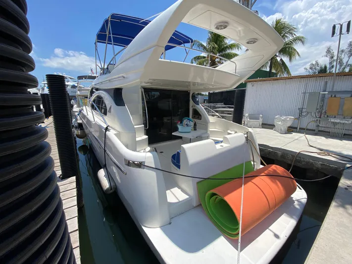  Yacht Photos Pics Azimut 46 yacht from 2000 docked, featuring a spacious deck and vibrant rolled mats.