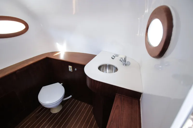  Yacht Photos Pics Luxurious 2018 Winter Custom Yachts Center Console bathroom with wooden accents and porthole window.