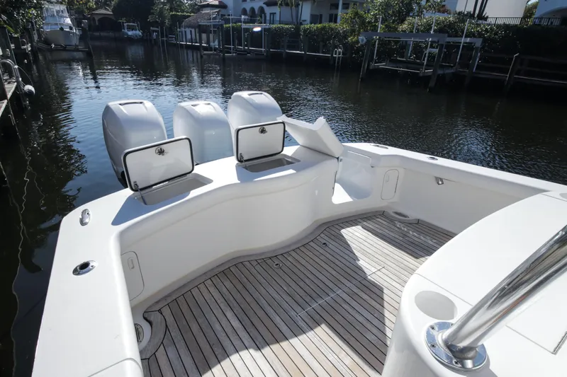  Yacht Photos Pics 2018 Winter Custom Yachts Center Console boat with open storage compartments, docked by a canal.
