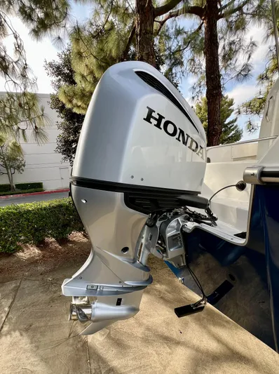  Yacht Photos Pics Silver Honda outboard motor on NJM NSB-28 boat, 2023 model, surrounded by trees.