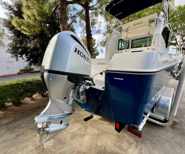  Yacht Photos Pics 2023 NJM NSB-28 boat with Honda outboard motor, parked outdoors.