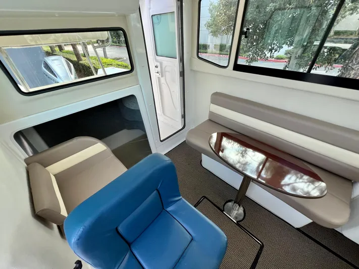  Yacht Photos Pics Interior of 2023 NJM NSB-28 boat with seating and table, featuring modern design.