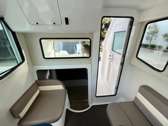  Yacht Photos Pics Interior of 2023 NJM NSB-28 boat, featuring seating and windows.