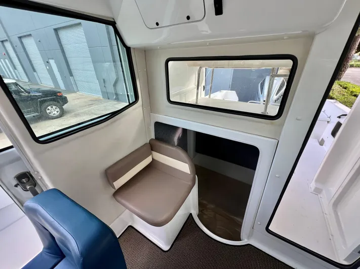  Yacht Photos Pics Interior of 2023 NJM NSB-28 boat with seating and window view.