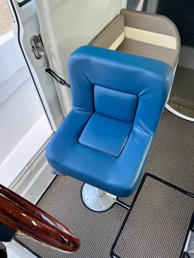  Yacht Photos Pics Blue captain's chair in NJM NSB-28 boat, 2023 model, with brown and beige accents.