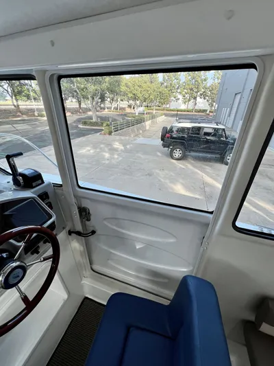  Yacht Photos Pics Interior view of 2023 NJM NSB-28 boat with blue seating and steering wheel.