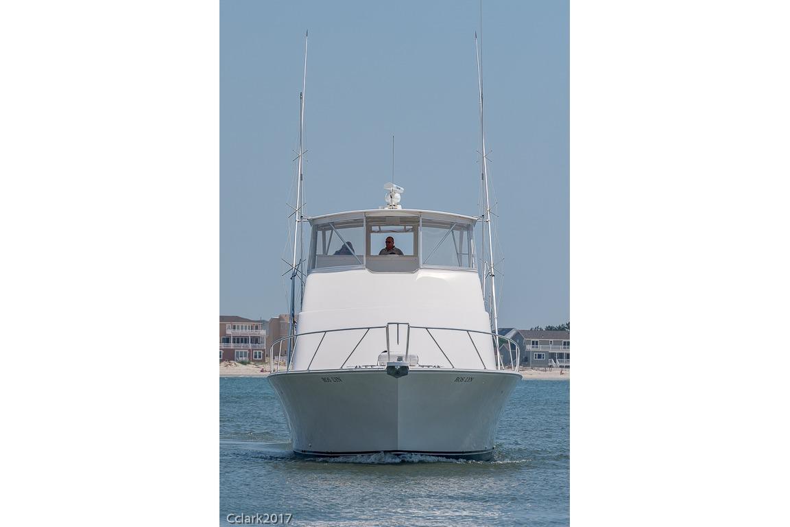 Front view of a 2007 Post 53 Convertible boat on water, with coastal background.